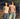 Two women standing outdoors in a natural setting, wearing tank tops and jeans.