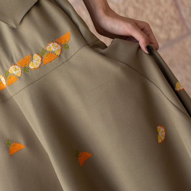 Close-up of handmade Jaffa orange tatreez embroidery on the KUVRD skirt