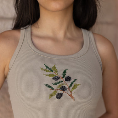 Close-up of olive (zaytoun) tatreez embroidery on the KUVRD tank