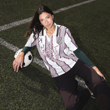 Model wearing KUVRD X FC Palestina Freedom Club Jersey on a soccer field with a ball.