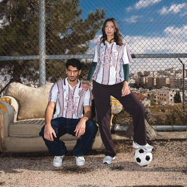 Two people on a rooftop with a cityscape in the background